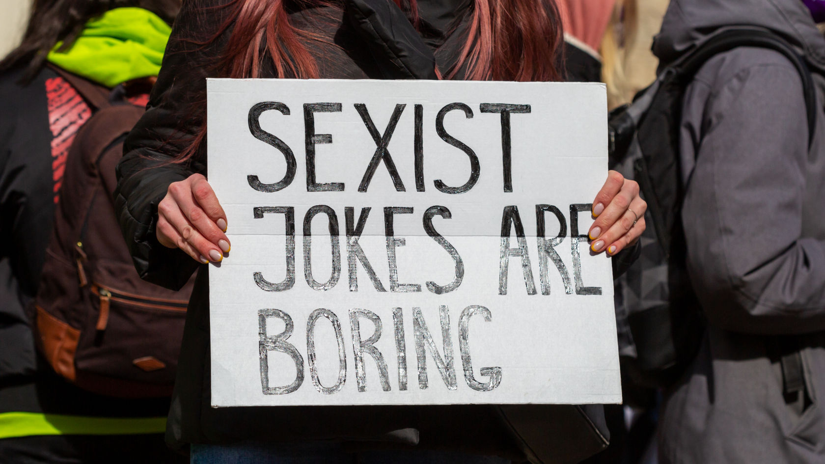 Ein Demonstrationsplakat, auf dem steht: "Sexist jokes are boring"